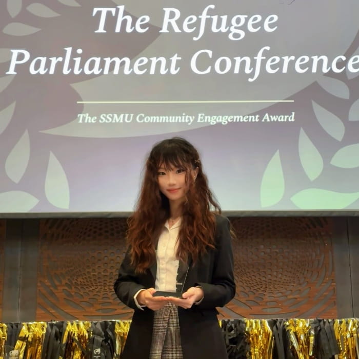 Jasmine receiving an award at the Refugee Parliament Conference