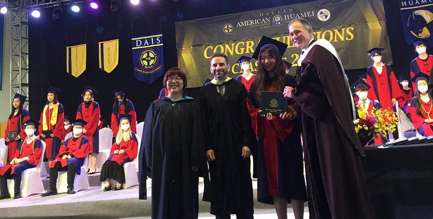 Student with principals during graduation